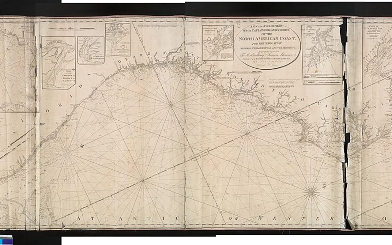 An old engraved paper sea chart of a coastline with a compass rose