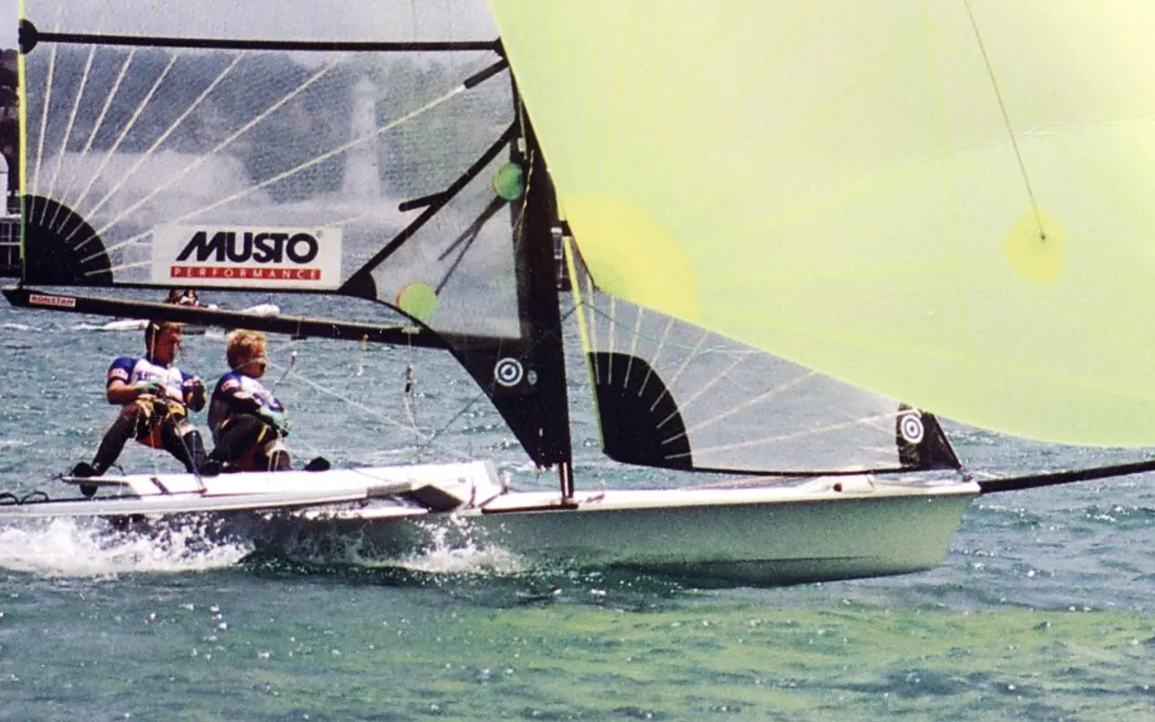 A two-person 49er skiff planing with crew on trapeze