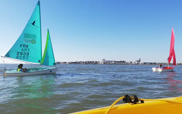 Eine kleine Hansa-303-Jolle unter Segeln, eine Person sitzt tief im Cockpit