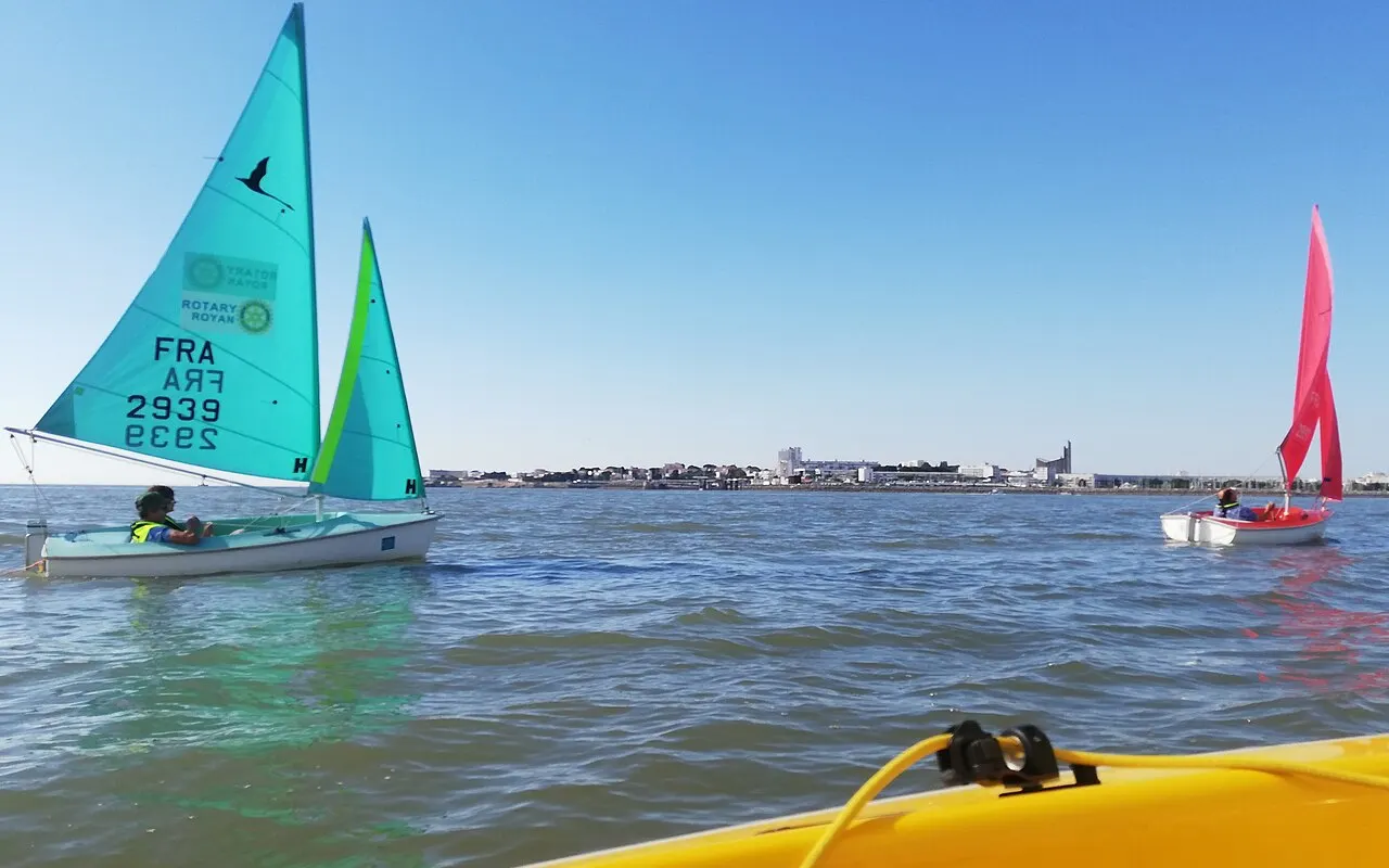 A small Hansa 303 dinghy sailing with one person seated low in the cockpit