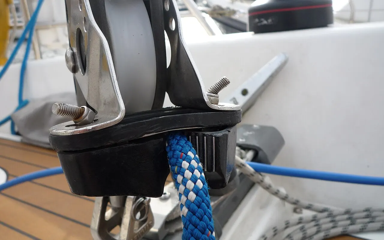 A cam cleat holding a blue line on a sailing boat