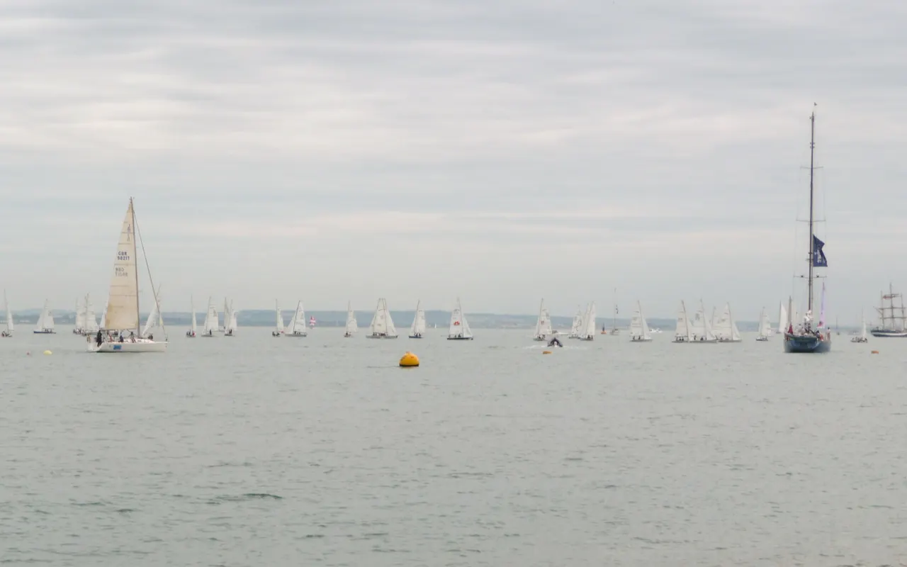Many sailing yachts racing close together in the Solent during Cowes Week
