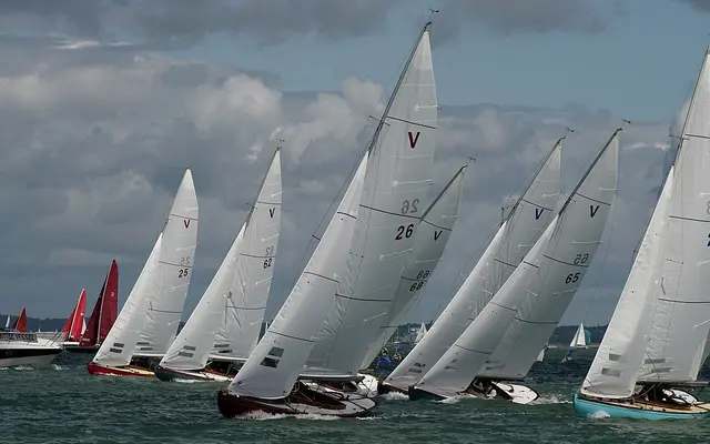 Eine Flotte von Yachten mit weißen Segeln bei einer Regatta in der Cowes Week