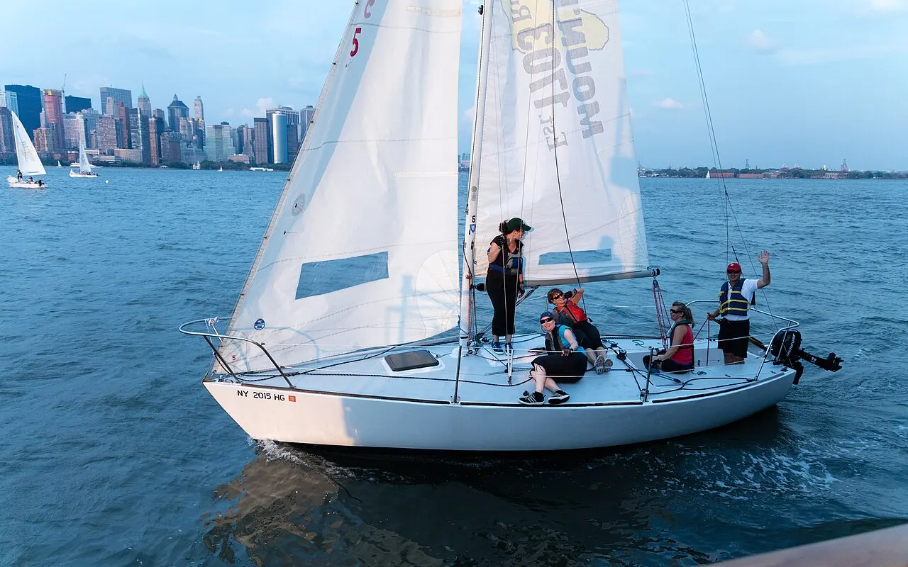A small keelboat with a group of sailors learning on a sunny day