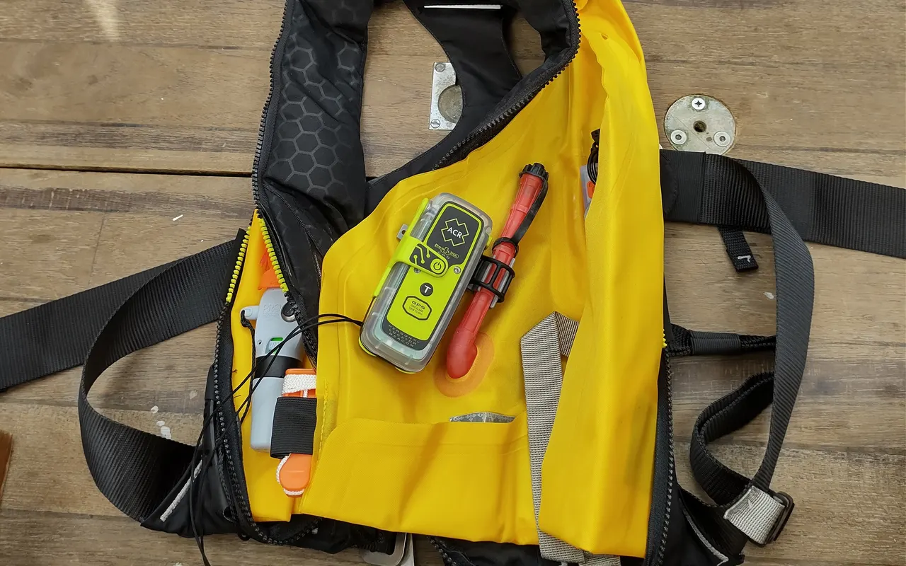 A yellow inflatable lifejacket opened up to show a personal locator beacon fitted inside