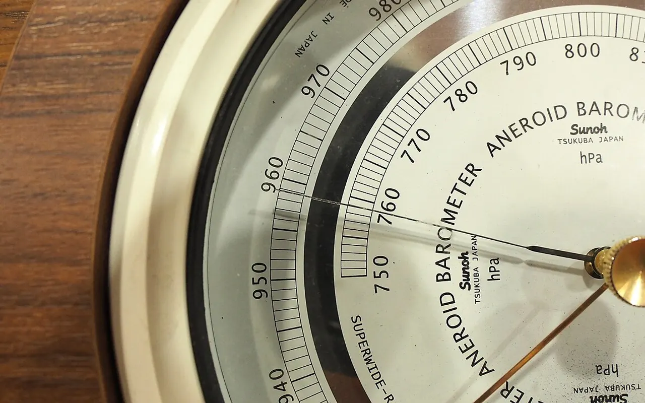 Close-up of an aneroid barometer dial marked in hectopascals
