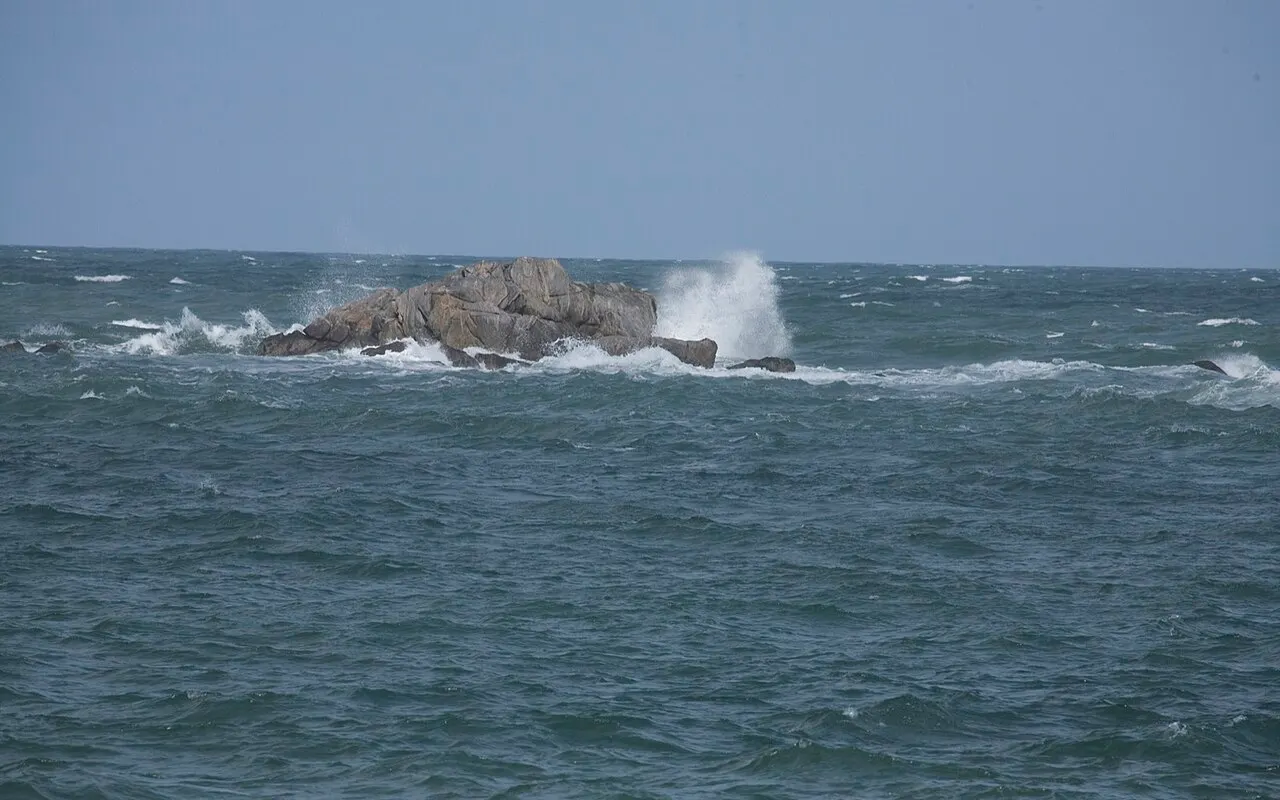 Une mer grise et agitée qui déferle sur les rochers près du rivage