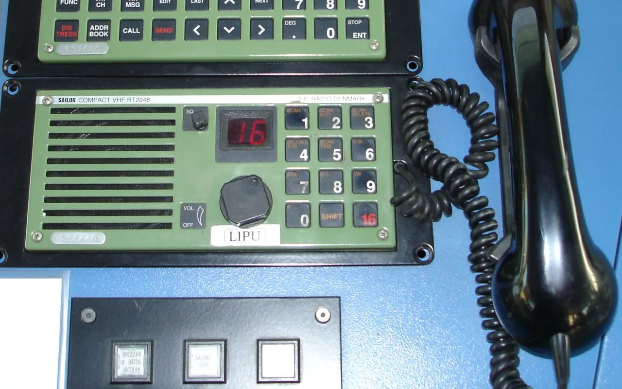 Una radio VHF marina fija con micrófono, que muestra el canal 16