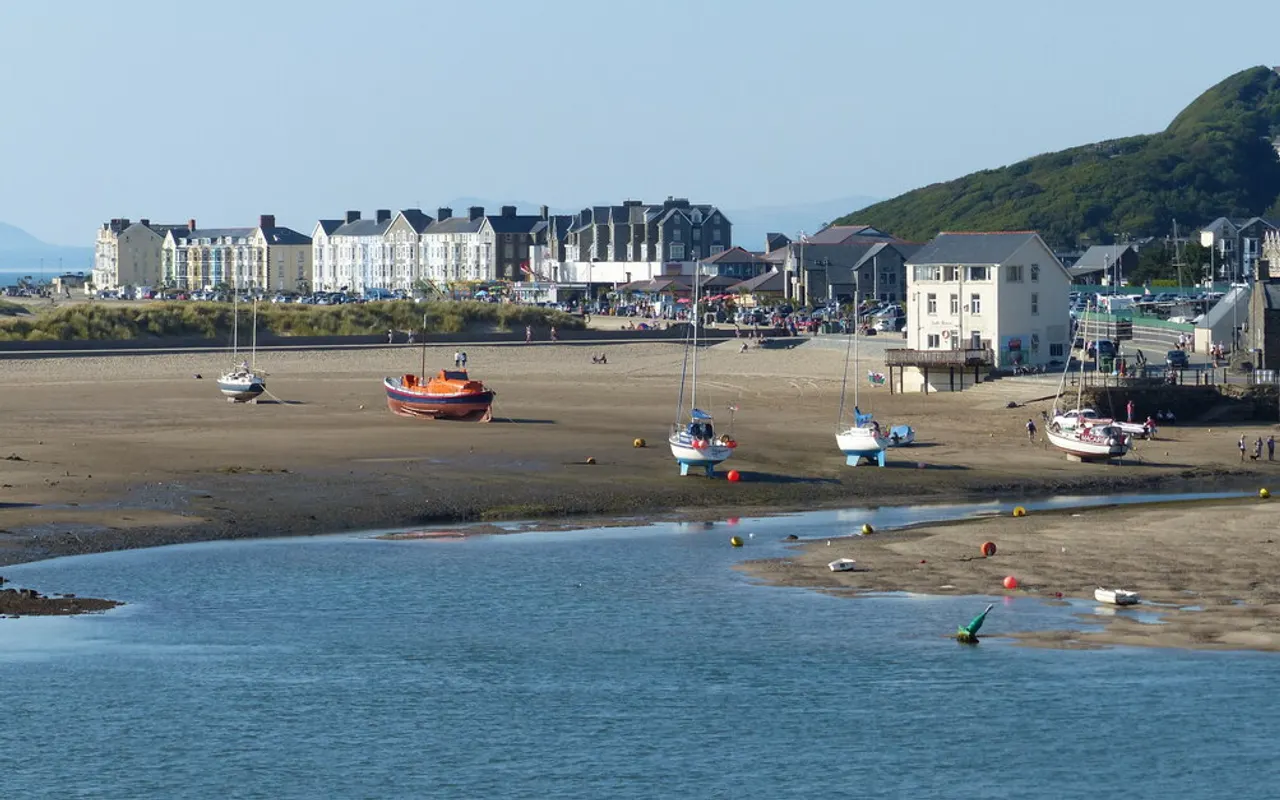 Bateaux posés sur le sable dans un port à marée basse, le chenal au-delà