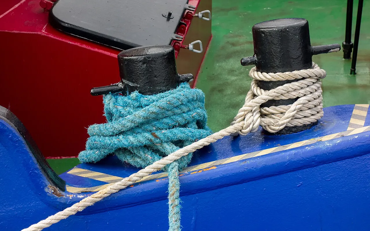 Cabos de amarre amarrados a bolardos en la cubierta de un barco