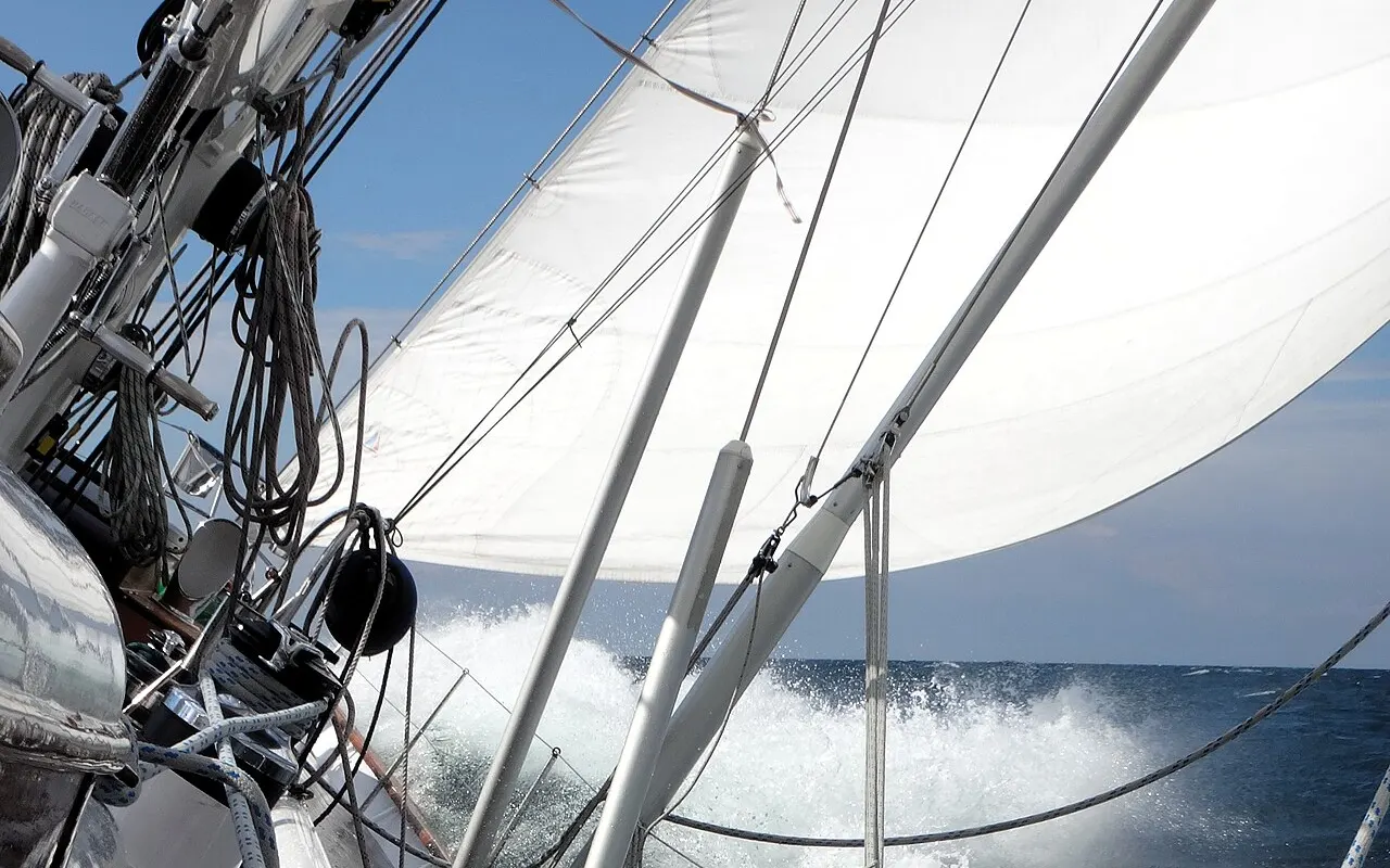 A sailing yacht pushing through rough water in a fresh breeze