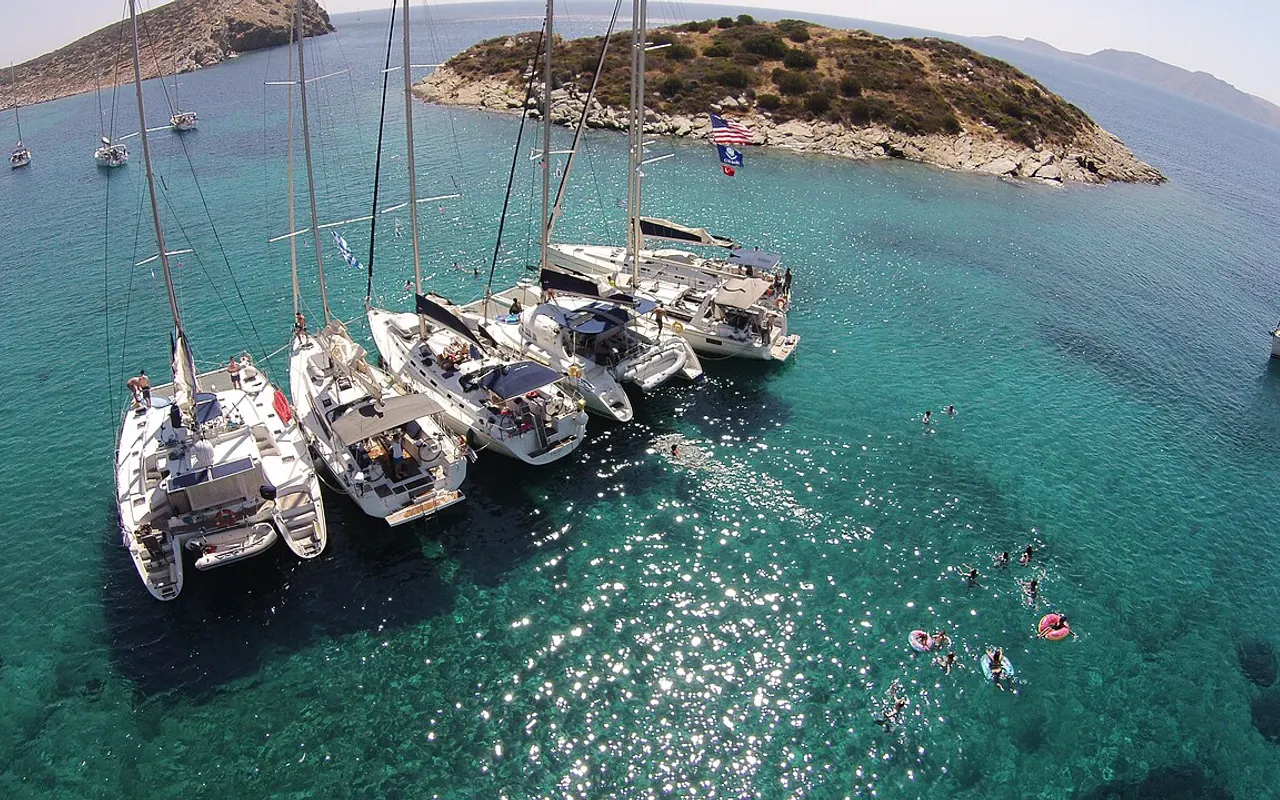 Aerial view of several yachts rafted together side by side in clear water