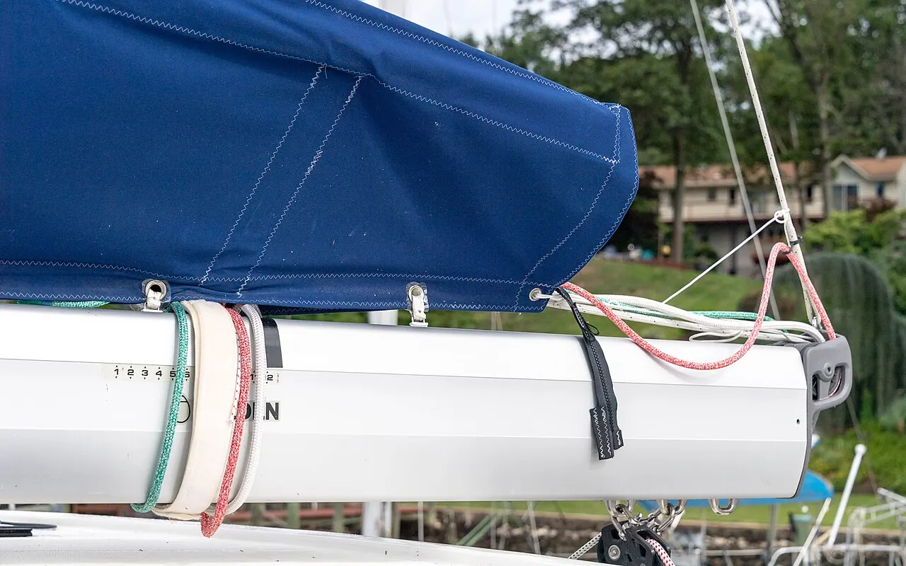 A mainsail stowed along a yacht's boom with ties