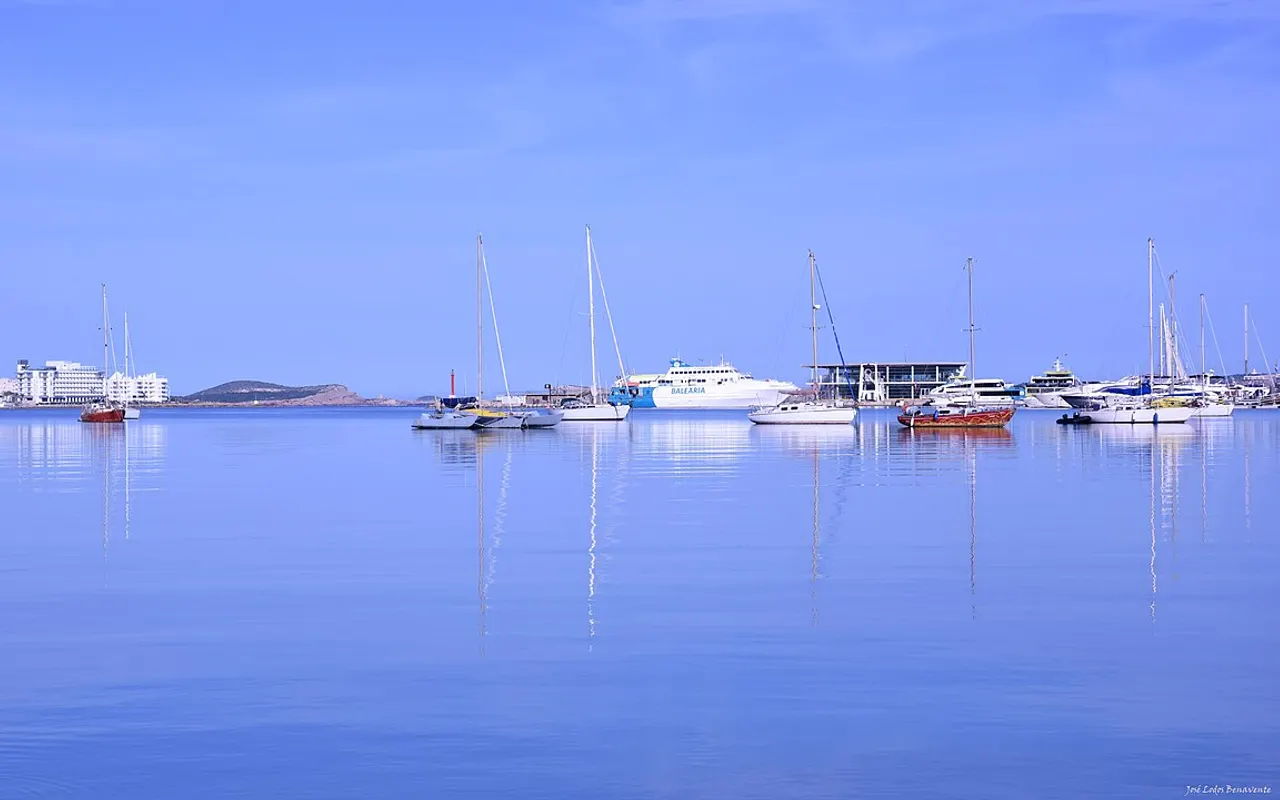 Mer calme et lisse avec des voiliers au mouillage au large d'une ville