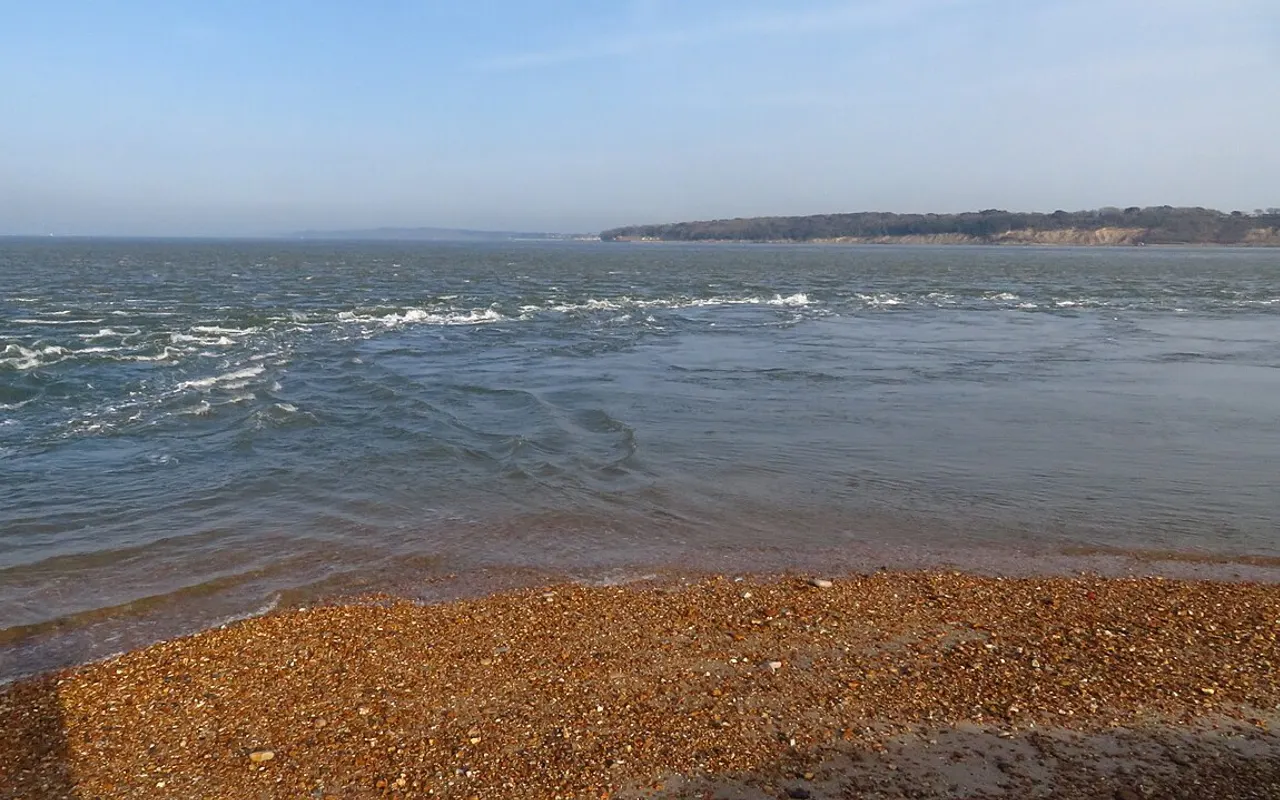 Fast tidal race running between a shingle spit and a coastline