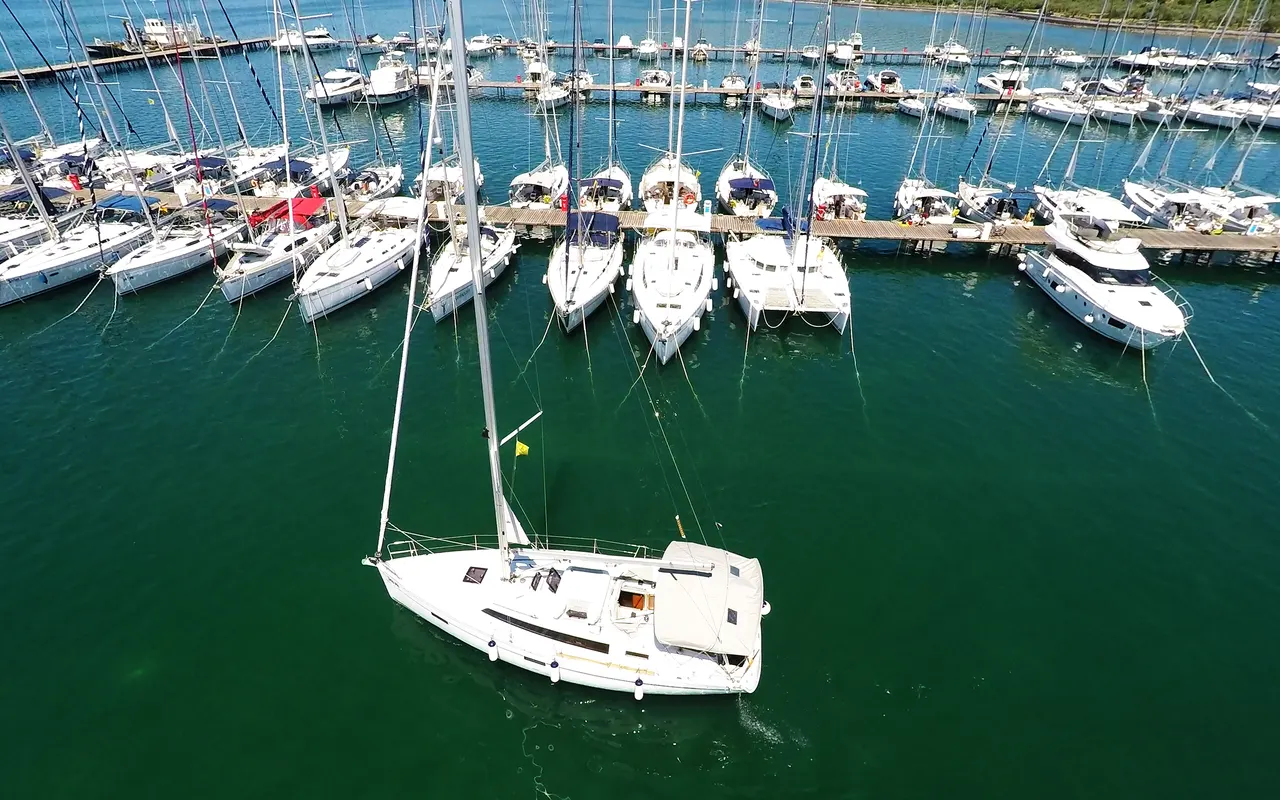 Aerial view of a sailing yacht leaving a marina full of boats at Punat, Croatia