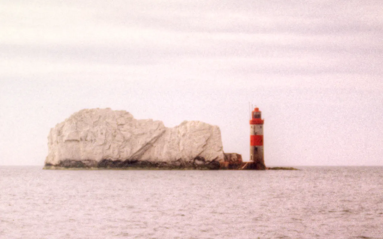 The red and white Needles lighthouse at the tip of the chalk stacks off the Isle of Wight