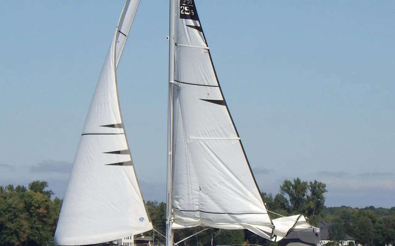 A small cruising yacht sailing upwind under mainsail and jib