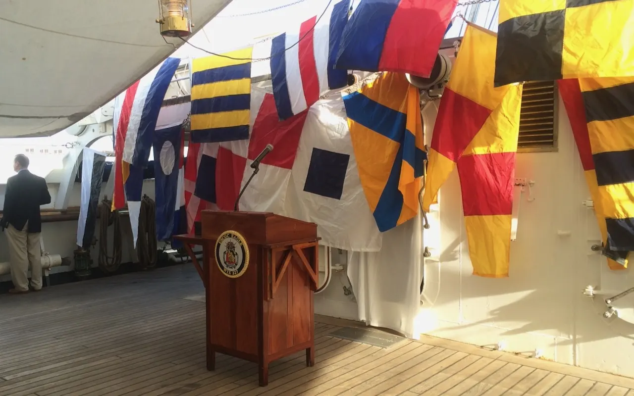 Rows of colourful international code flags hanging on the deck of a sail training ship
