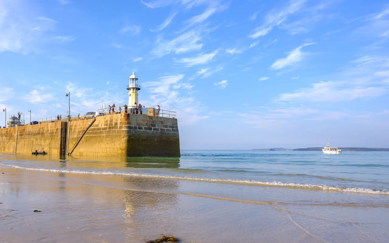 The harbour pier and lighthouse at St Ives, Cornwall, with the harbour dried out at low tide