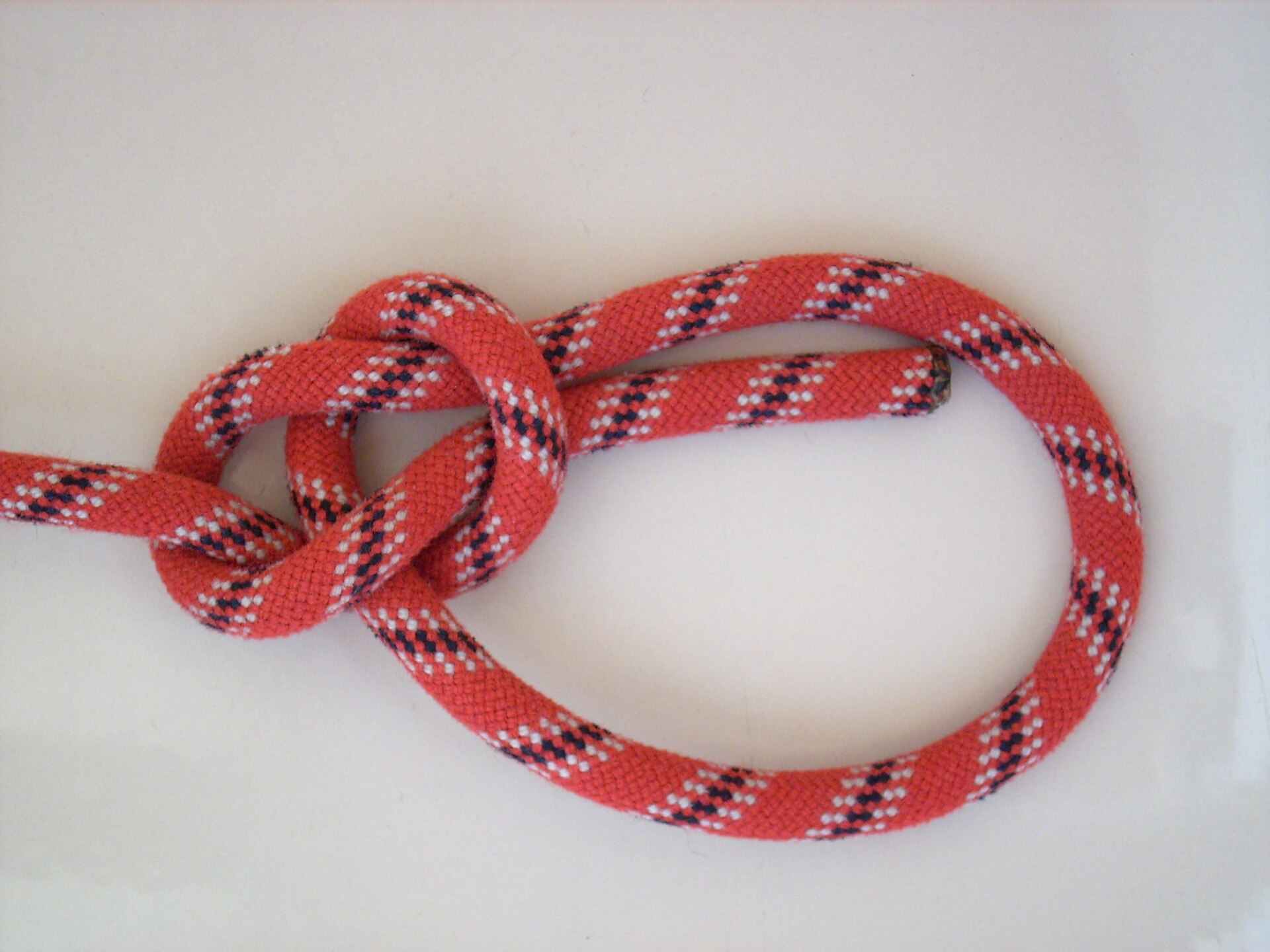A finished bowline tied in red climbing rope