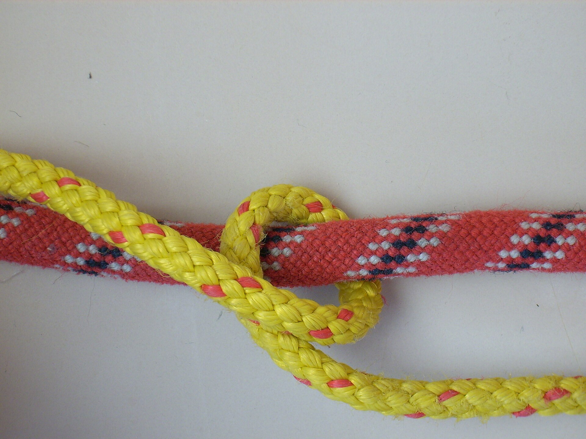 Yellow line taking its first turn round a red rope
