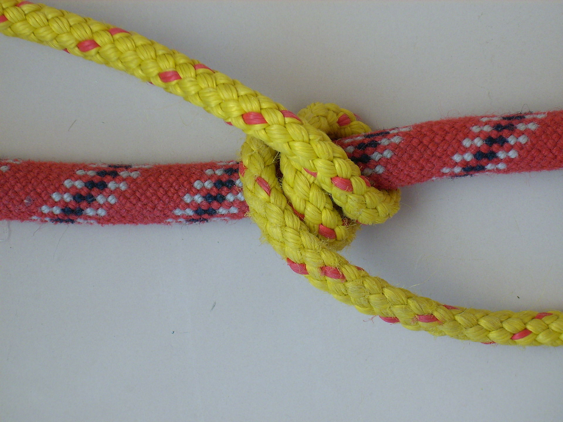 Two riding turns of yellow line round the red rope