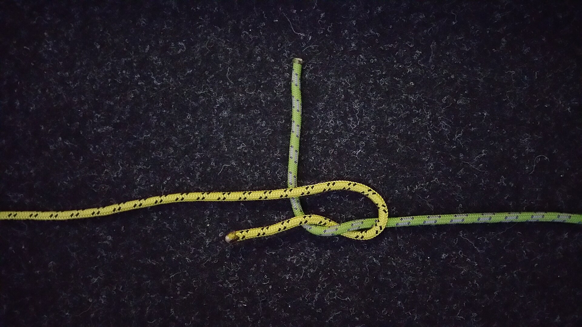 The green rope taken round behind both legs of the yellow bight