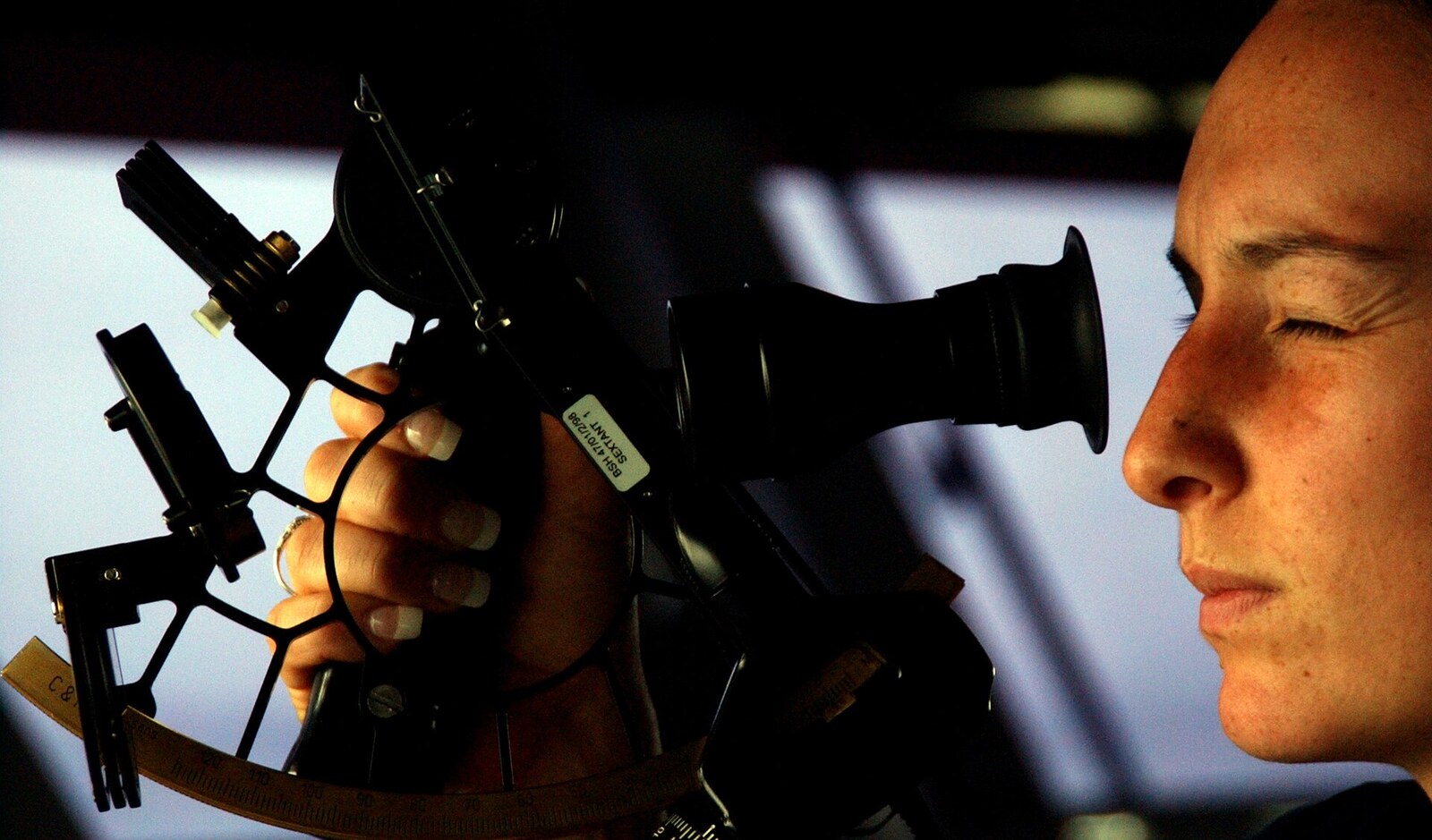 A navigator takes a sextant sight at sea