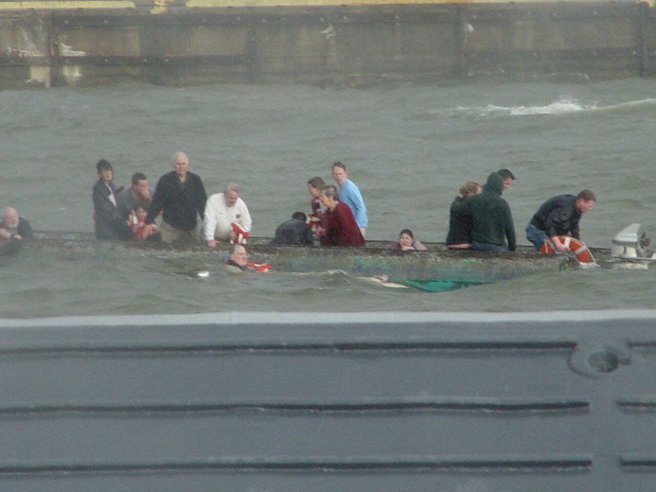 Survivors of the Lady D capsize cling to the overturned water taxi in Baltimore's Inner Harbor in 2004